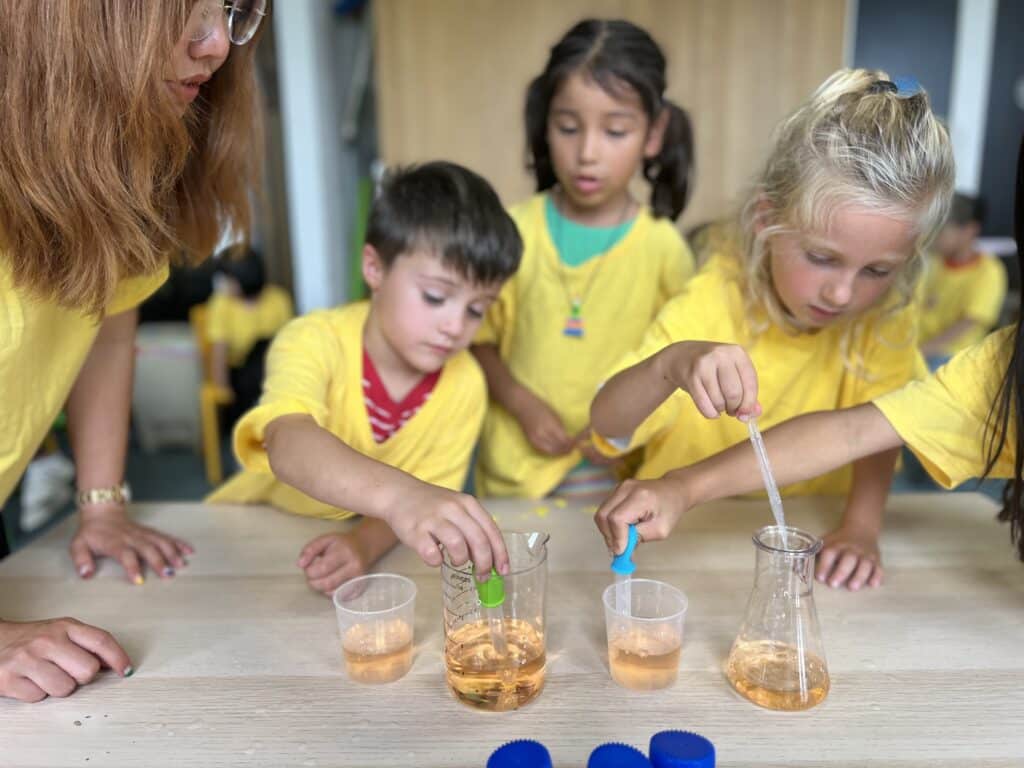 Children and adults engaging in a science experiment with liquids.
